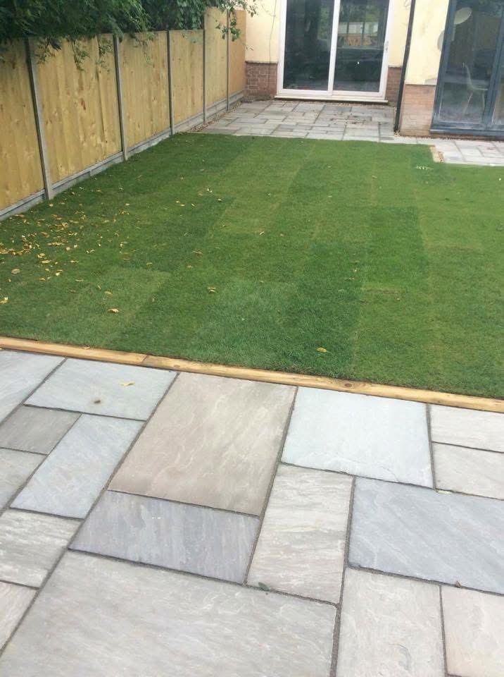 New turf lawn with sandstone patio and timber edging