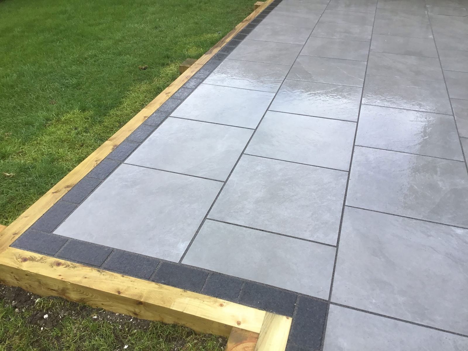 Grey porcelain patio with black block border
